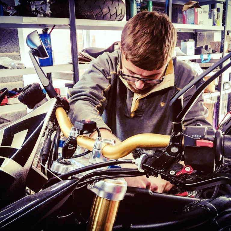 Auto electrician working on a triumph motorbike to find a wiring fault